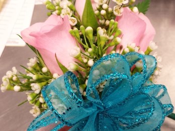Pink rose corsage with blue ribbon