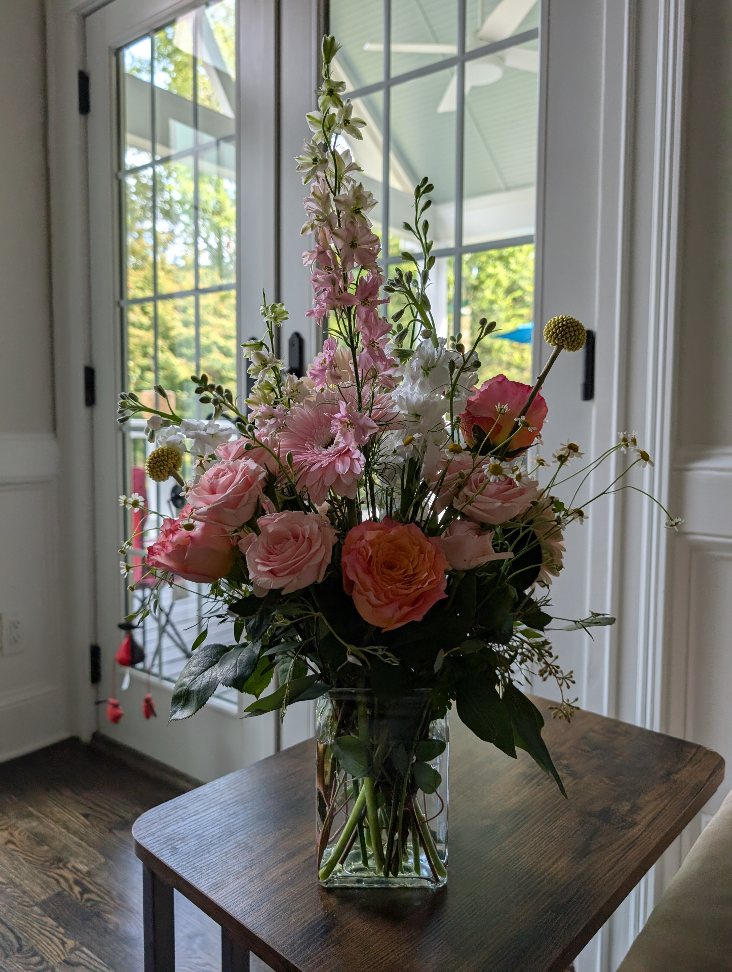 Pink roses with tall delphinium arrangement